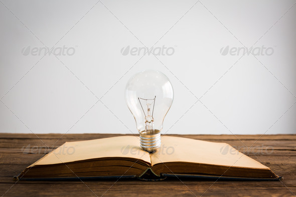 vintage book and light bulb on wood table (Misc) Photo Download