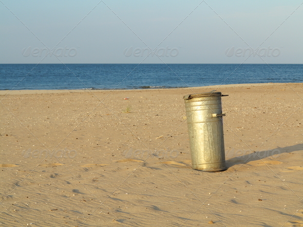 Gray metal garbage bin or can on beach (Misc) Photo Download